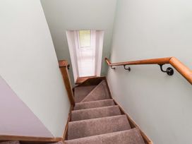 A staircase with a handrail and a window at The Lodge in Powburn