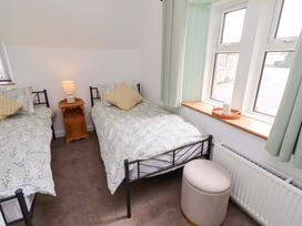 A bedroom with two beds and a bedside table at The Lodge in Powburn