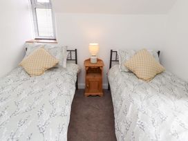 A bedroom with two beds and a lamp on a side table at The Lodge in Powburn