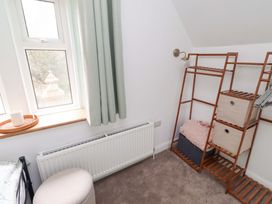 A bedroom with a window, radiator, shelf unit, and storage boxes at The Lodge in Powburn