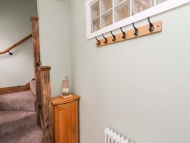 A hallway with hooks and a staircase at The Lodge in Powburn