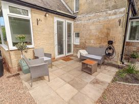 A patio area with chairs and a table at The Lodge in Powburn