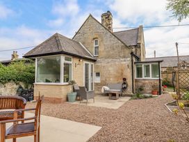 A garden area with chairs and a house at The Lodge in Powburn