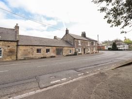 A building on the roadside with signage at The Running Fox in Powburn