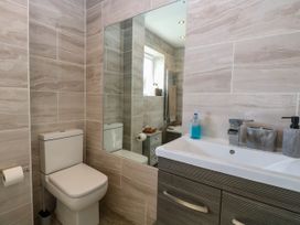 A bathroom with a toilet sink and mirror at 6 Barleycroft in Hemsby