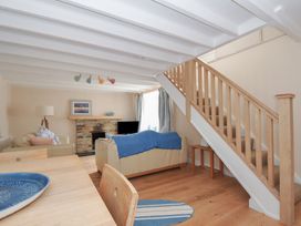 A living room with a sofa and dining table at 2 Porthilly Cottages Rock