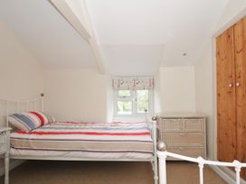 A bedroom with a bed and chest of drawers at 2 Porthilly Cottages Rock