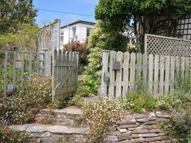 A garden gate and path with flowers at 2 Porthilly Cottages in Rock
