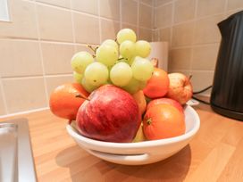 A bowl of mixed fruit including apples grapes and oranges on a kitchen counter at Meadow Cottage in Staintondale near Cloughton