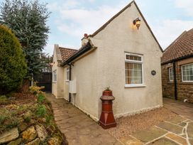 The exterior side of a single story house with stone pavement and garden at Meadow Cottage in Staintondale near Cloughton