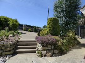 A garden with steps leading up to a pathway at Meadow Cottage in Staintondale near Cloughton