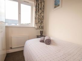 A bedroom with a bed and towels on it at 1 Vetch Avenue in St Austell