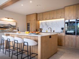 A kitchen with bar stools and an island at Deer Close in Coniston