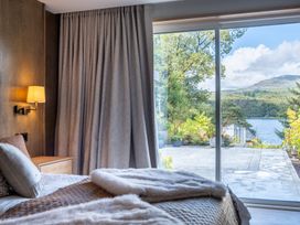 A bedroom with a bed and window overlooking a lake at Deer Close in Coniston