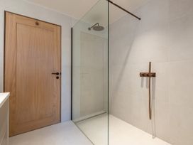 A bathroom with a shower and wooden door at Deer Close in Coniston