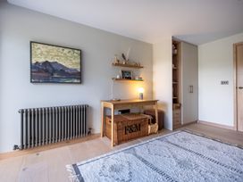 A room with a table, shelf, and radiator at Deer Close in Coniston