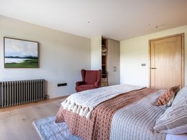 A bedroom with a bed and chair at Deer Close in Coniston