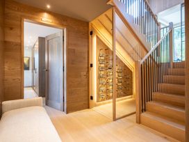 A hallway with a staircase and wine rack at Deer Close in Coniston