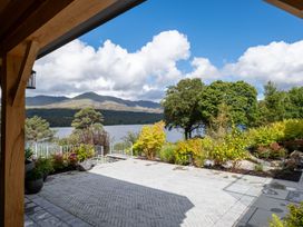 A view overlooking a lake surrounded by mountains and greenery at Deer Close in Coniston