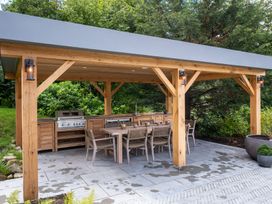 An outdoor kitchen with grill and dining table at Deer Close in Coniston