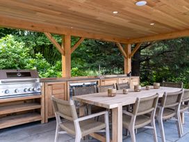 An outdoor kitchen with a grill and dining area at Deer Close in Coniston