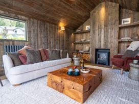 A living room with a sofa, coffee table, and fireplace at Deer Close in Coniston
