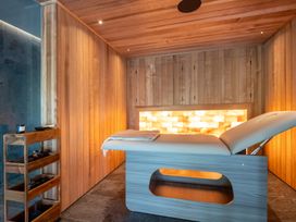 A spa room with a massage table and wooden walls at Deer Close in Coniston
