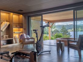 A fitness area with exercise equipment and large windows overlooking a lake at Deer Close in Coniston