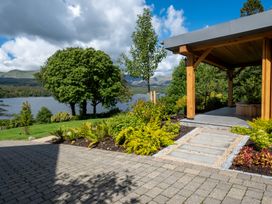 A garden with a pathway and gazebo near a lake at Deer Close in Coniston