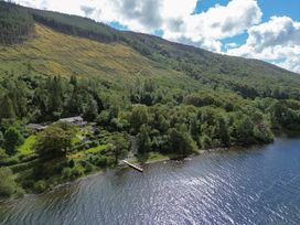 An outdoor view of a house and garden by a lake at Deer Close in Coniston