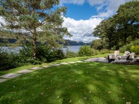 A garden with a pathway, seating area, and lake view at Deer Close in Coniston