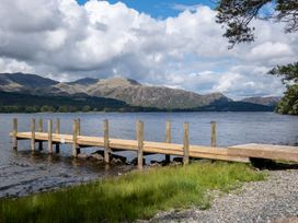 A dock extending into water with mountains in the background at Deer Close in Coniston