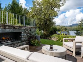 An outdoor patio with a fireplace and seating area at Deer Close in Coniston