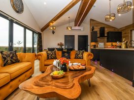 A living room with orange sofas and wooden coffee table next to a kitchen and dining area at Routhorpe Lodge Bainton near Great Driffield