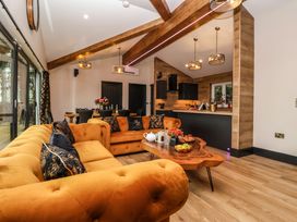 A living room with orange sofas wooden beams and a wooden coffee table with fruit and tea set at Routhorpe Lodge Bainton near Great Driffield