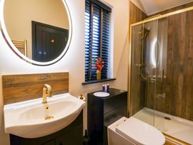 A bathroom with a sink faucet mirror shower and toilet at Routhorpe Lodge in Bainton near Great Driffield