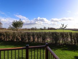 A garden with a hedge and trees overlooking farmland and fields at Routhorpe Lodge in Bainton near Great Driffield