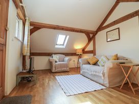 A living room with sofas pillows and a lamp at Woodland Retreat Lodge Brundish near Laxfield