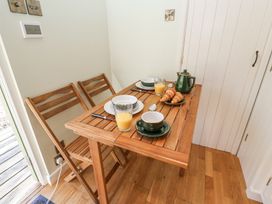 A wooden dining table with two chairs set with plates croissants orange juice and a teapot at Woodlands Retreat Shepherd's Hut in Brundish near Laxfield