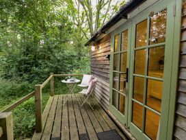 An outdoor patio with a table and chairs at Woodlands Retreat Shepherd's Hut Brundish near Laxfield