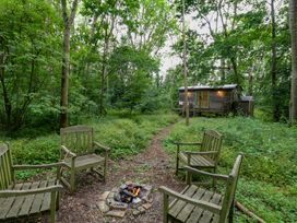 An outdoor space with chairs and a fire pit at Woodlands Retreat Shepherd's Hut in Brundish near Laxfield