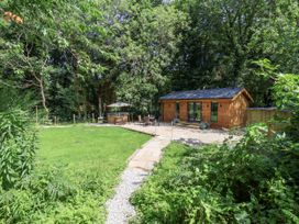An outdoor area with a wooden cabin and seating at Roe Deer Lodge in Littlebeck near Sleights