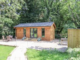 A wooden cabin with a table and chairs in the outdoor area at Roe Deer Lodge in Littlebeck near Sleights
