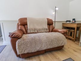 A sofa with a throw blanket and a lamp at Roe Deer Lodge Littlebeck near Sleights