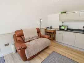A living room with a sofa and a kitchen unit at Roe Deer Lodge Littlebeck near Sleights