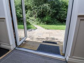 An entrance with a door open to a pathway and grassy area at Roe Deer Lodge Littlebeck near Sleights