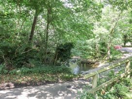 A wooded area with a stream beside a road at Roe Deer Lodge Littlebeck near Sleights
