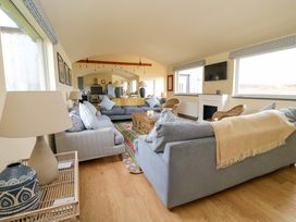 A living room with two gray sofas, a wooden coffee table, and a fireplace at WildLuing in Cullipool Isle Of Luing