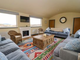 A living room with sofas wicker chairs a wooden coffee table and a fireplace at WildLuing Cullipool Isle Of Luing