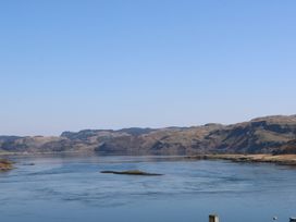 A body of water with hills in the background at WildLuing in Cullipool Isle Of Luing